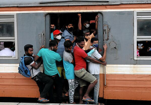 مسافرون يرتدون كمامات في قطار مزدحم متجه نحو العاصمة، وسط مخاوف من انتشار مرض الفيروس التاجي (كوفيد-19)، في كولومبو، سريلانكا، 8 يوليو 2020. - سبوتنيك عربي