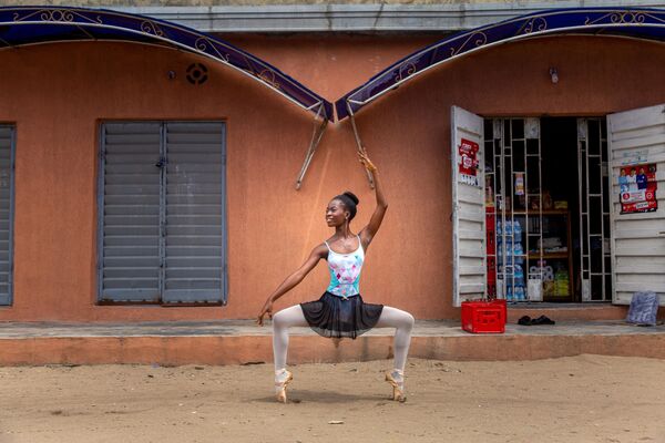 طالبة من أكاديمية ليب أوف دانس لرقص الباليه، تدعى أولاميد أولوال، تؤدي تدريبا روتينًا للرقص في إحدى شوراع مدينة أجانغبادي، لاغوس، 3 يوليو 2020. وتمنح أكاديمية الباليه، في أفقر مناطق أفريقيا، فرصة تعلم الرقص الكلاسيكي للأطفال المحرومين مجانا. - سبوتنيك عربي