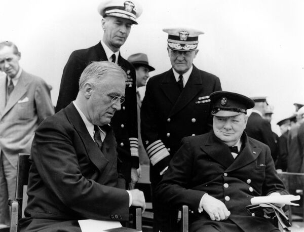 الرئيس الأمريكي فرانكلين روزفلت ورئيس الوزراء البريطاني ونستون تشرشل يجتمعان على متن السفينة الحربية البريطانية إتش إم إس أمير ويلز خلال المؤتمر الأطلسي لمدة خمسة أيام في القاعدة البحرية العسكرية أرجنتينيا باي، قبالة نيوفاوندلاند، كندا ، في 10 أغسطس/ آب 1941.  يستمعون خلفهم (من اليسار) الأدميرال إي. كينغ، قائد الأسطول الأطلسي البحري الأمريكي والأدميرال هارولد ر. ستارك، رئيس العمليات البحرية الأمريكية. - سبوتنيك عربي