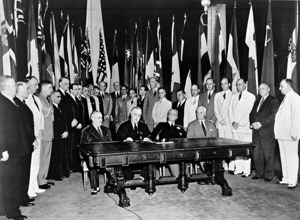 في 1 يناير/ كانون الثاني 1942، اجتمع ممثلو 26 دولة حليفة، التي تحارب ضد لدول المحور، في واشنطن العاصمة ليتعهدوا بدعم الميثاق الأطلسي من خلال التوقيع على إعلان الأمم المتحدة. احتوت هذه الوثيقة على أول استخدام رسمي لمصطلح الأمم المتحدة، الذي اقترحه رئيس الولايات المتحدة فرانكلين ديلانو روزفلت (جالس، الثاني من اليسار). - سبوتنيك عربي