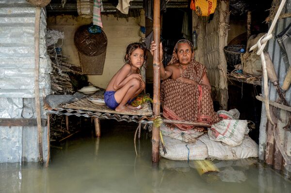 فيضانات آسيا، فتاة تجلس بجوار امرأة في بنغلادش، بعد الفيضانات الكبيرة التي أصابت معظم مناطق آسيا 16 يوليو 2020 - سبوتنيك عربي