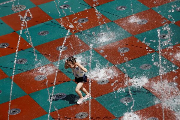 فتاة تلعب بمياه النافورة في يوم صيفي حار في مجمع للتسوق في بكين، الصين 14 يوليو 2020 - سبوتنيك عربي