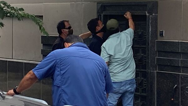 مجموعة من الأشخاص يستخدمون أدوات كهربائية لمحاولة فتح باب خلفي للقنصلية الصينية في هيوستن - سبوتنيك عربي
