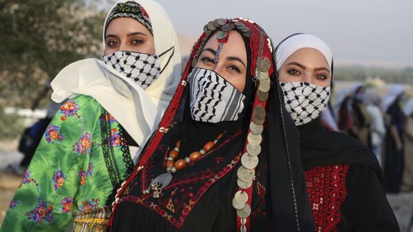 فتيات فلسطينيات يرتدين الثوب الفلسطيني، و كمامات على شكل كوفية، احتفالا بيوم الزي الفلسطيني في قرية الجفتلك وادي الأردن، 26 يوليو 2020 - سبوتنيك عربي