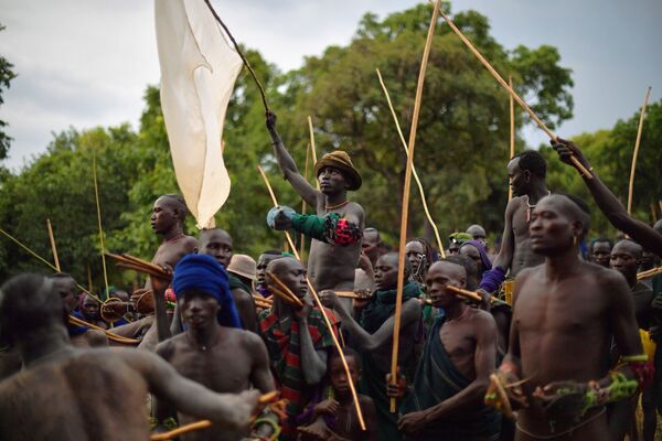رجال من قبيلة سوري يحملون على أكتافهم فائزا في مسابقة دونغا (قتال بالعصي) التقليدية في القبيلة، في منطقة وادي أومو جنوب إثيوبيا - سبوتنيك عربي