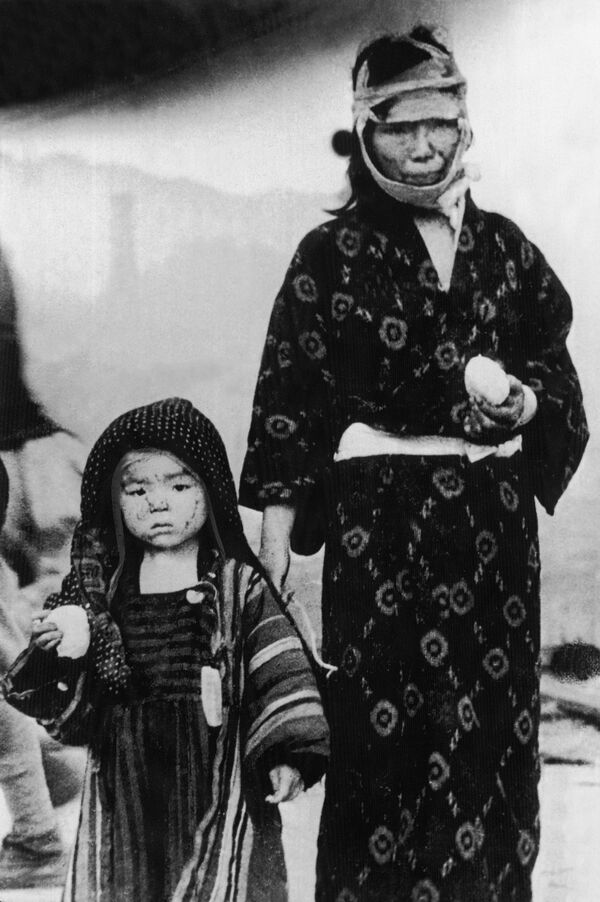 صورة من الأرشيف - امرأة يابانية مع طفلها يرتديان ملابس يابانية تقليدية، بعد نجاتهما من القنبلة الذرية التي ألقيت على ناغازاكي، بتاريخ 9 أغسطس/ آب 1945. - سبوتنيك عربي