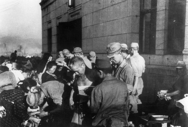 صورة بتاريخ 6 أغسطس/ آب عام 1945 - يظهر فيها الجرحى والمصابين في هيروشيما، الذين يتلقون المساعدة الأولية والعلاج  من قبل القوات العسكرية اليابانية في أغسطس/ آب 1945 - سبوتنيك عربي