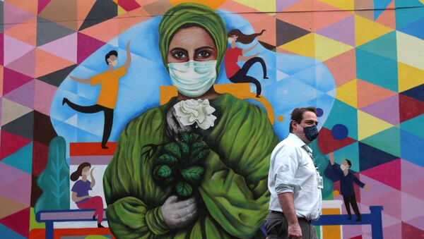 رجل يسير بجوار جدارية عن تأبين ضحايا الأطقم الطبية جراء فيروس كورونا المستجد في سان باولو بالبرازيل - سبوتنيك عربي