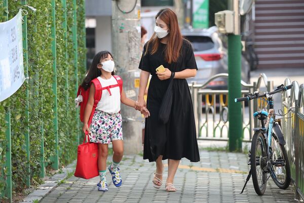 أم تقوم بتوصيل ابنتها إلى المدرسة في سئول، في إطار الاجراءات الاحترازية لمنع تفشي فيروس كورونا، كوريا الجنوبية 25 أغسطس 2020 - سبوتنيك عربي