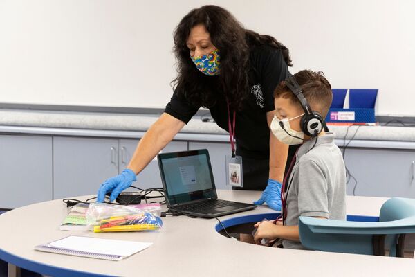 مساعد معلم والتلميذ يرتديان كمامات طبية في مدرسة في فينيكس، في إطار الاجراءات الاحترازية لمنع تفشي فيروس كورونا، ولاية أريزونا، الولايات المتحدة 16أغسطس 2020 - سبوتنيك عربي