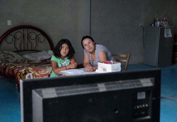 أم تساعد طفلتها أثناء الدرس عن بعد، في إطار الاجراءات الاحترازية لمنع تفشي فيروس كورونا، المكسيك 24 أغسطس 2020 - سبوتنيك عربي