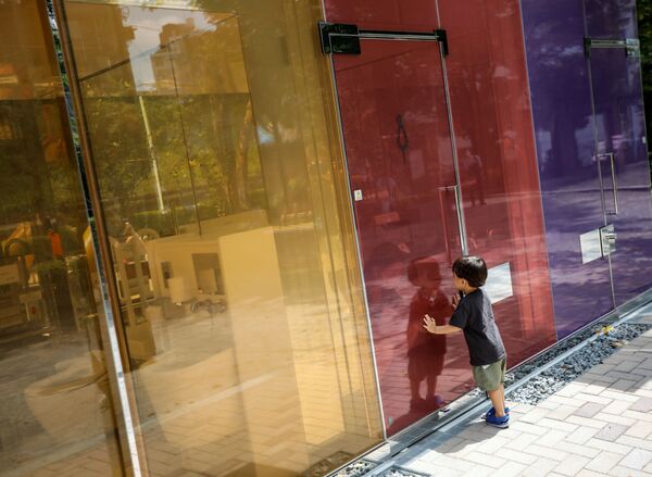 طفل ينظر عبر الجدران الشفافة لمرحاض عام في حديقة يويوجي فوكاماتشي ميني بارك في طوكيو، اليابان 26 أغسطس 2020 - سبوتنيك عربي