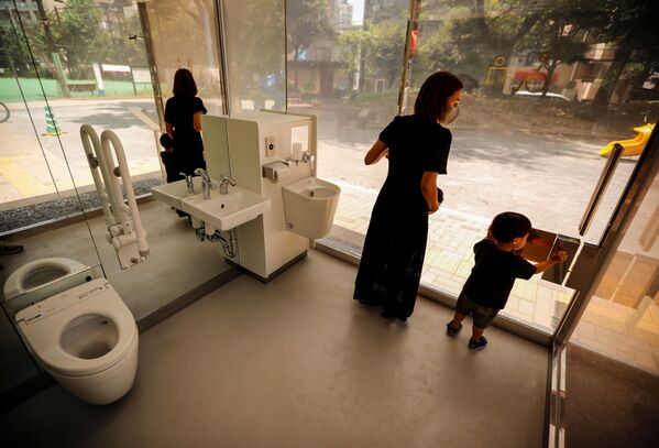 أم مع طفلها يتفقدان المرحاض بالجدران الشفافة في حديقة يويوجي فوكاماتشي ميني بارك في طوكيو، اليابان 26 أغسطس 2020 - سبوتنيك عربي