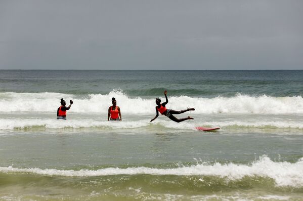 الفتاة السنغالية خادجو سامبي، 25 عاما، أول امرأة محترفة في ركوب الأمواج في السنغال، خلال تدريب الفتيات على ركوب الأمواج في دكار 28 يوليو/ تموز  2020 - سبوتنيك عربي