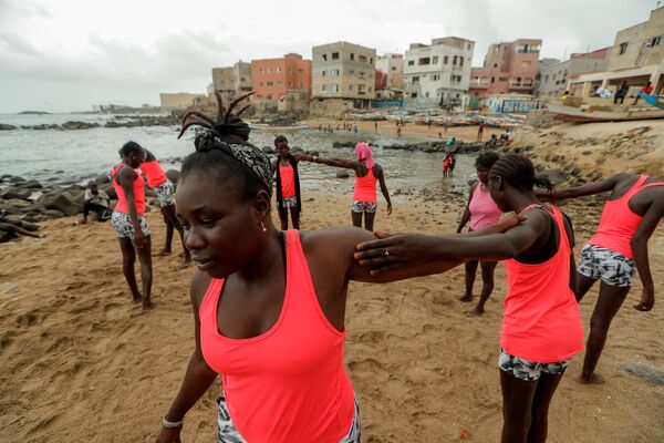 الفتاة السنغالية خادجو سامبي، 25 عاما، أول امرأة محترفة في ركوب الأمواج في السنغال، أثناء تدريب الفتيات على ركوب الأمواج، في دكار 3 أغسطس/ آب 2020 - سبوتنيك عربي