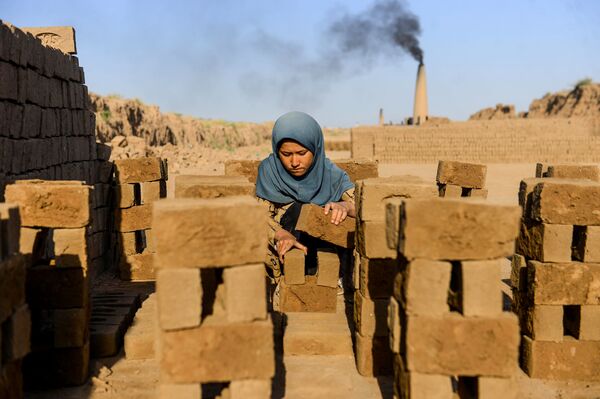 فتاة تجمع الطوب، وهي عاملة في مصنع للطوب في ضواحي مدينة هارت في أفغانستان 26 أغسطس 2020 - سبوتنيك عربي