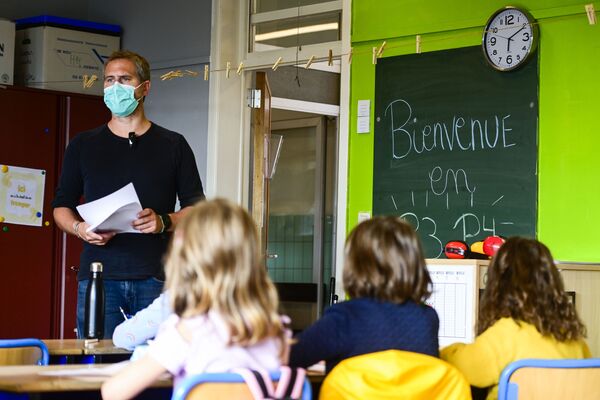 مدرّس إبتدائي يرتدي كمامة طبية خلال الفصل الدراسي في مدرسة في بروكسل، بلجيكا 1 سبتمبر 2020 - سبوتنيك عربي