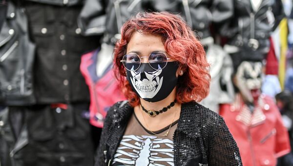 امرأة ترتدي كمامة مرسوم عليها وجه جمجمة في مكسيكو سيتي، المكسيك 25 يوليو 2020 - سبوتنيك عربي