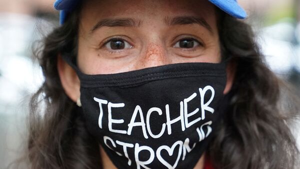 امرأة ترتدي كمامة مكتوب عليها معلم قوي، احتجاجا على إعادة فتح المدارس وسط تفشي  فيروس كورونا في مدينة نيويورك، الولايات المتحدة 1 سبتمبر 2020 - سبوتنيك عربي