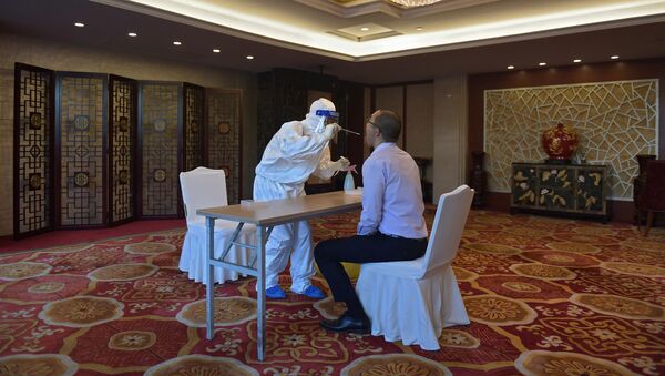  موظف يقوم بعمل اختبار لأحد المشاركين في مراسم تكريم الأطباء والمتطوعين (قبل بدء الحفل) في مكافحة تفشي فيروس كورونا (كوفيد-19)، في قاعة الشعب الكبرى في بكين، 8 سبتمبر 2020 - سبوتنيك عربي