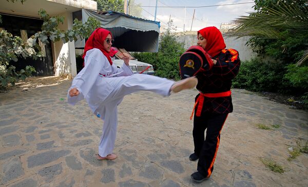 مدربة الفنون القتالية وبطلة الكيك بوكسينج اليمنية سهام عامر أثناء التدريبات في منزل إحدى المتدربات في صنعاء، اليمن 5 سبتمبر 2020 - سبوتنيك عربي