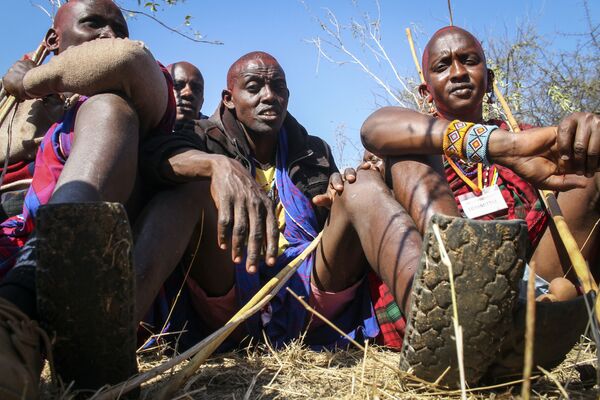 يرتدي أحد أفراد قبيلة ماساي موران (أو المحارب) صندلًا مصنوعًا من قطعة إطار السيارات، حيث يشارك هو وآخرون في احتفالات أولنغيشير (Olng'esherr) عند تلال ماباراشا، بالقرب من كاجيادو في كينيا، 23 سبتمبر  2020 - سبوتنيك عربي