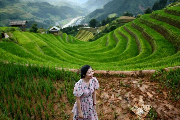 فتاة تأخذ مكانا مناسبا لالتقاط صورة على خلفية مدرجات الأرز مو تسانغ تشاي، فيتنام 18 سبتمبر 2020 - سبوتنيك عربي