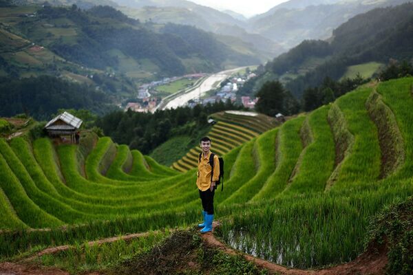 رجل يختار مكانا لالتقاط صورة على خلفية مدرجات الأرز مو تسانغ تشاي، فيتنام 18 سبتمبر 2020 - سبوتنيك عربي