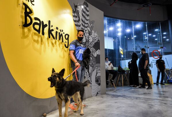 رجل برفقة كلبه الراعي الألماني في مقهى Barking Lot في مدينة الخبر، المملكة العربية السعودية 25 سبتمبر 2020 - سبوتنيك عربي