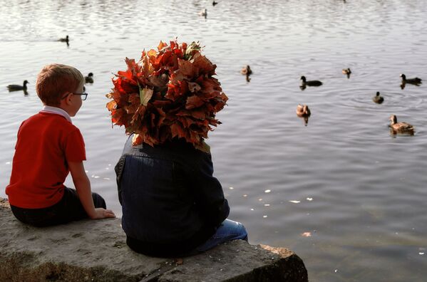 أطفال يجلسون على ضفاف بحيرة بلاك في بلدة غاتشينا، إقليم لينينغراد، روسيا 27 سبتمبر 2020 - سبوتنيك عربي