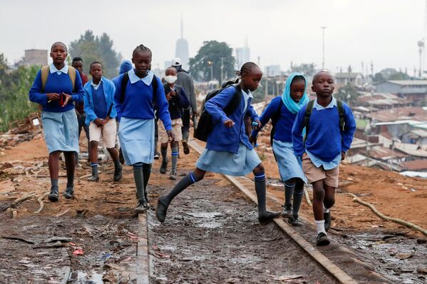 أطفال المدارس يسيرون على طول خط السكة الحديدية بين كينيا وأوغندا وسط إعادة الافتتاح الجزئي للمدارس، بعد أن ألغت الحكومة خططًا لإلغاء العام الدراسي بسبب جائحة فيروس كورونا (كوفيد-19)، في أحياء كيبيرا الفقيرة في نيروبي، كينيا، 12 أكتوبر  2020 . - سبوتنيك عربي