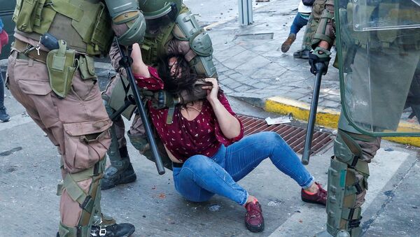 احتجاز الشرطة لأحد المتظاهرين أثناء احتجاجات مناهضة لحكومة تشيلي في فالبارايسو، 19 أكتوبر 2020 - سبوتنيك عربي
