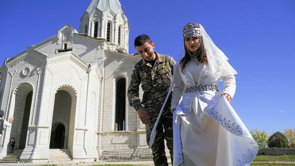 هوفانيس هوفسيبيان ومريم سركسيان، من سكان ناغورني قره باغ، يقيمان حفل زفافهما في كاتدرائية غزانتشيتسوت الأرمنية (كاتدرائية المسيح القديس المخلص)، في بلدة شوشي (شوشا)، بينما لايزال النزاع العسكري في المنقطة مستمرا بين أرمينيا وأذربيجان، 24 أكتوبر 2020 - سبوتنيك عربي