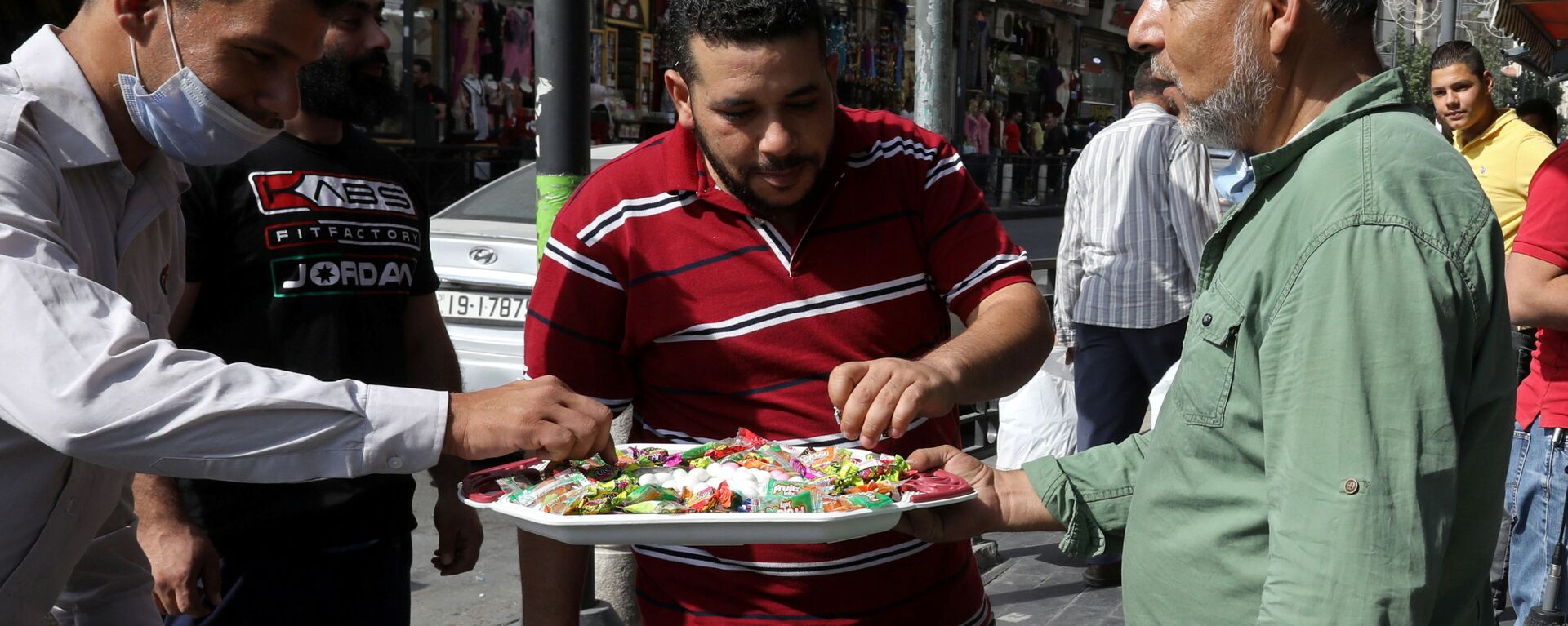 مواطن أردني يقوم بتوزيع الحلو على الزبائن والمارة بمناسبة إحياء ذكرى المولد النبوي في مدينة عمان، الأردن  29 أكتوبر/ تشرين الأول 2020 - سبوتنيك عربي, 1920, 12.02.2021