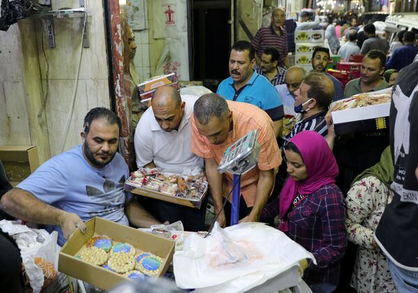 مواطنون يشترون الحلويات بمناسبة إحياء ذكرى المولد النبوي في القاهرة، مصر 28 أكتوبر/ تشرين الأول 2020 - سبوتنيك عربي
