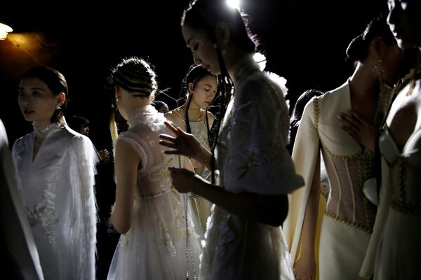 عاضرات أزياء بستعدن للخروج على منصة عرض أزياء هيفن غايا/  مجموعة صيف 2021 من تصميم الصيني شيونغ ينغ، خلال أسبوع الموضة في الصين في بكين، الصين، 24 أكتوبر/ تشرين الأول 2020. - سبوتنيك عربي