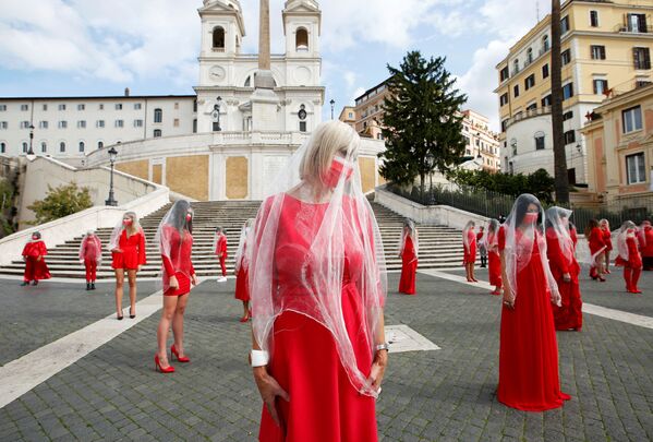 نساء يرتدين ملابس حمراء في سبانش ستيبس أثناء تسجيلهن مقطع فيديو لنشر التوعية بالعنف الاجتماعي القائم على التمييز الجنسي، قبل اليوم العالمي للقضاء على العنف ضد المرأة في 25 نوفمبر في روما، إيطاليا، 26 أكتوبر 2020 - سبوتنيك عربي