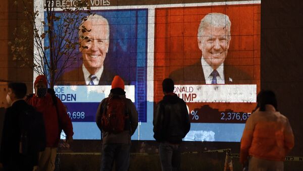 مواطنون يراقبون نتائج التصويت في الانتخابات الرئاسية الأمريكية 2020 على شاشة تلفاز كبيرة في أحد شوارع مدينة واشنطن، 3 نوفمبر 2020 - سبوتنيك عربي