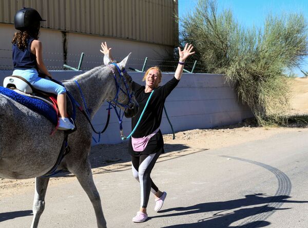 ياسمين السيد، مؤسِّسة برنامج Ride to Rescue، تقدم دروسًا في ركوب الخيل لفتاة في نادي مندرة للفروسية في أبو ظبي، الإمارات العربية المتحدة، 21 أكتوبر 2020 - سبوتنيك عربي