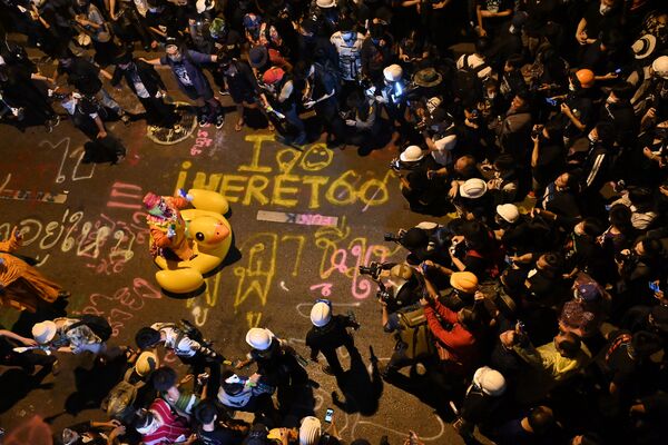المصورون الصحفيون يلتقطون صورًا لمهرج  يقف داخل بطة مطاطية ضخمة، أثناء مظاهرات مؤيدة للديمقراطية ومناهضة للحكومة في بانكوك، تايلاند 18 نوفمبر 2020. - سبوتنيك عربي