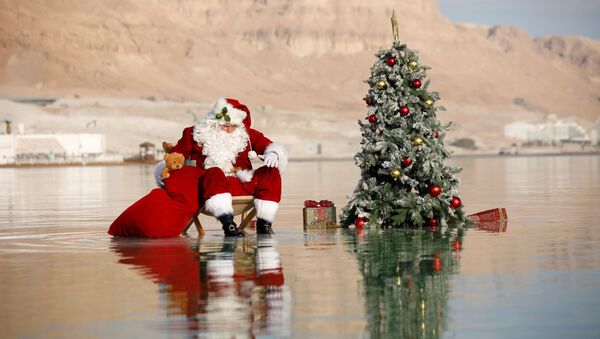 الفلسطيني عيسى قسيسية يرتدي زي بابا نويل وشجرة عيد الميلاد، أثناء جلسة تصوير في البحر الميت، في عين بكيك، 15 نوفمبر 2020 - سبوتنيك عربي
