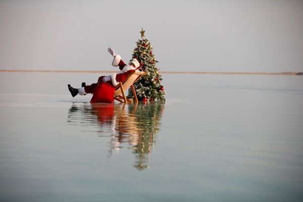 الفلسطيني عيسى قسيسية يرتدي زي بابا نويل وشجرة عيد الميلاد، أثناء جلسة تصوير في البحر الميت، في عين بكيك، 15 نوفمبر 2020 - سبوتنيك عربي