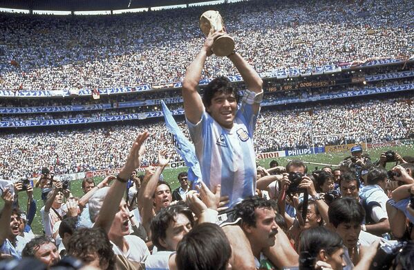 لاعب كرة القدم الأرجنتيني دييغو مارادونا، يحتفل بفوز منتخبه بكأس العالم في  1986 - سبوتنيك عربي
