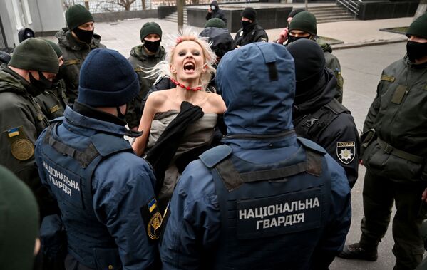 ضباط الشرطة يعتقلون ناشطة من حركة فيمين تحتج خارج مكتب الرئيس الأوكراني للاحتفال اليوم الدولي للقضاء على العنف ضد المرأة في كييف، أوكرانيا 25 نوفمبر 2020 - سبوتنيك عربي
