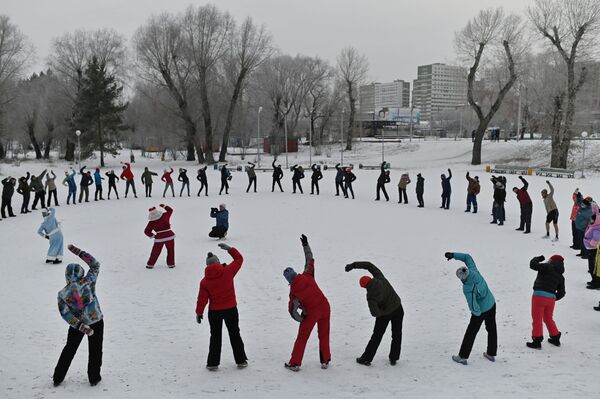 أهالي منطقة أومسك يمارسون تمارين  رياضية بالقرب من نهر إيرتيش في يوم افتتاح موسم السباحة الشتوية في أومسك، روسيا 6 ديسمبر 2020 - سبوتنيك عربي