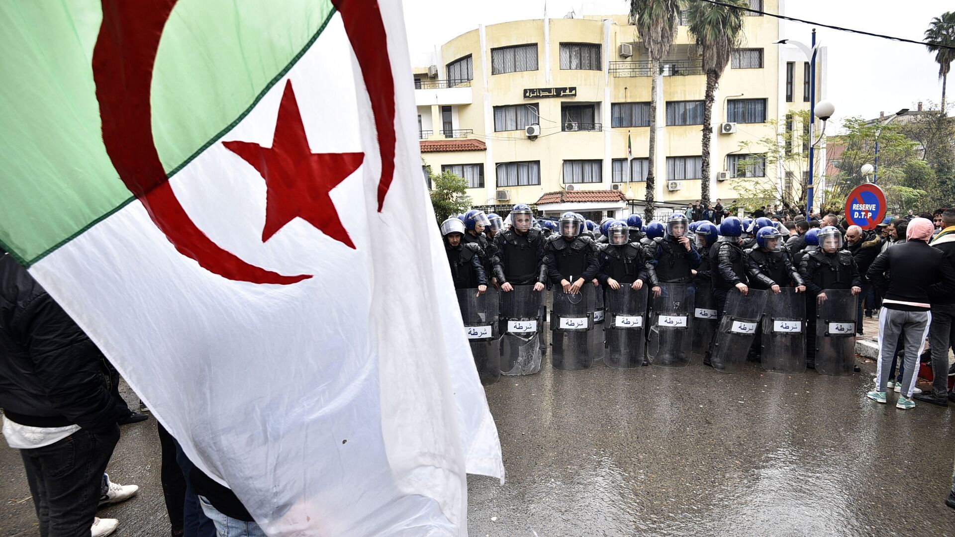قوات الأمن في مواجهة متظاهرين جزائريين تجمعوا على بعد حوالي 100 كلم شرق العاصمة الجزائر، 8 ديسمبر 2019 - سبوتنيك عربي, 1920, 06.05.2021