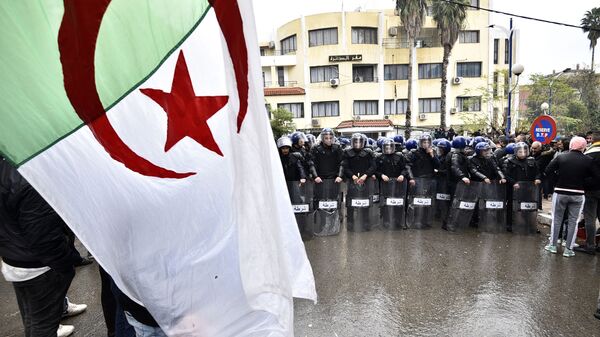 قوات الأمن في مواجهة متظاهرين جزائريين تجمعوا على بعد حوالي 100 كلم شرق العاصمة الجزائر، 8 ديسمبر 2019 - سبوتنيك عربي