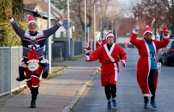 أشخاص يرتدون زي بابا نويل يتسابقون في شوارع ميشيندورف، بالقرب من برلين، خلال مهرجان نيكولاس لوف (سباق سانت نيكولاس)، وسط تفشي مرض فيروس كورونا (كوفيد-19)، ألمانيا، 6 ديسمبر 2020. - سبوتنيك عربي