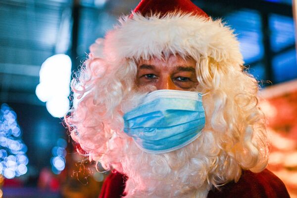 بابا نويل يرتدي كمامة ويرحب بالزوار عند الدخول إلى سوق عيد الميلاد في محطة الطاقة النووية القديمة في كالكار، غرب ألمانيا11 ديسمبر 2020 - سبوتنيك عربي