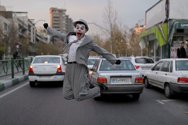 محمد، فنان شوارع إيراني يرتدي زي شخصية الجوكر، يقف مع أعضاء فرقة مسرحية أثناء عرض ترفيهي للمواطنين، وسط تفشي كورونا (كوفيد-19) في طهران، إيران، 12 ديسمبر 2020 - سبوتنيك عربي